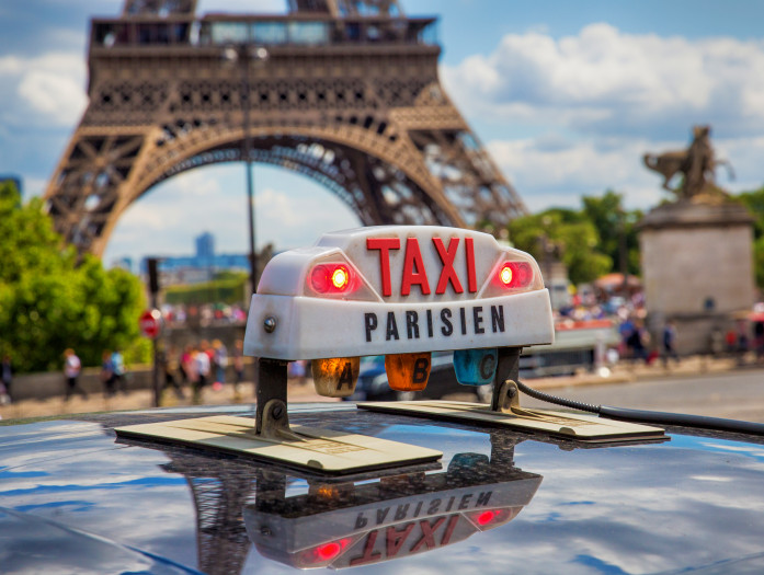 Taxi parisien écologique devant la Tour Eiffel 